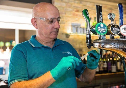 man cleaning beer taps